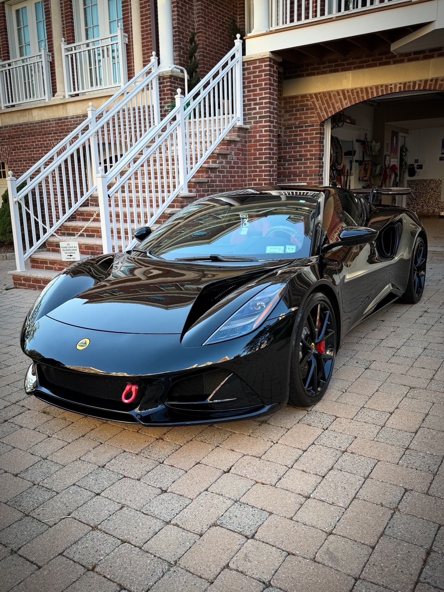 Black Lotus Emira kept in showroom condition on a brick paver driveway