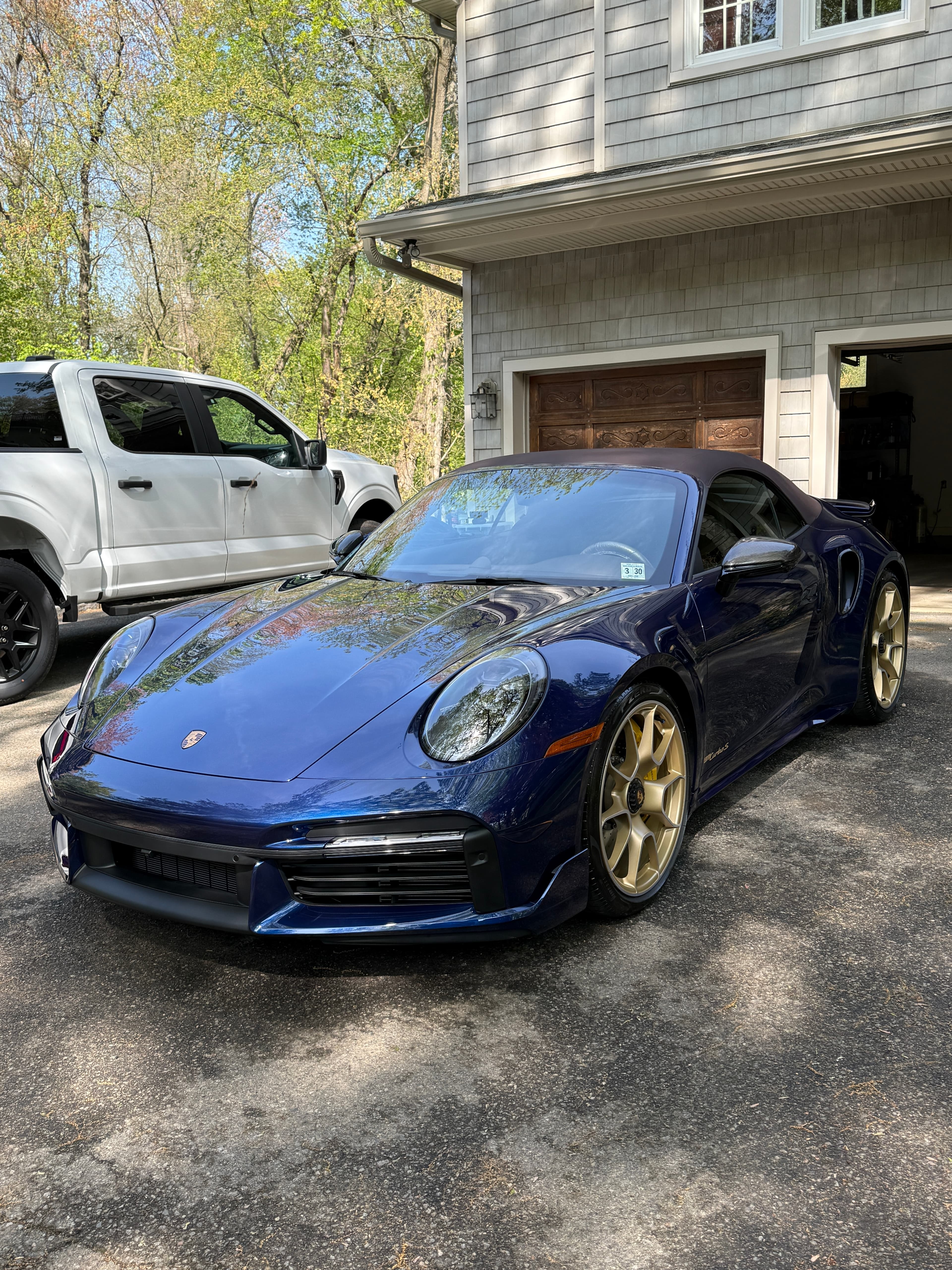 Dark blue Porsche 911 Turbo S with a freshly applied ceramic coating in a client's driveway